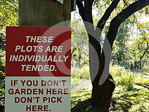 Red and white garden sign plots individually tended don`t pick