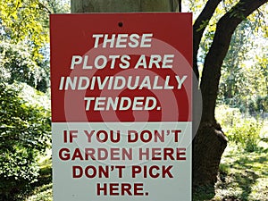 Red and white garden sign plots individually tended don`t pick