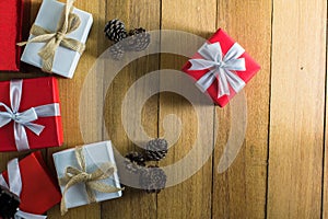 Red and white gift box with pine cones on wood table