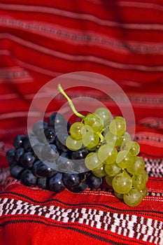 Red and white grapes on a traditional Romanian carpet