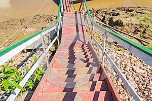 Red, white and green stairs on river bank.