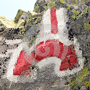 Red and white hiking trail signs symbols in Italy alps