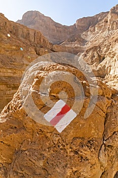 Red on white hiking/walking trail mark sign, in the Judean Desert