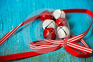 Red and white jingle bells with ribbon n blue background