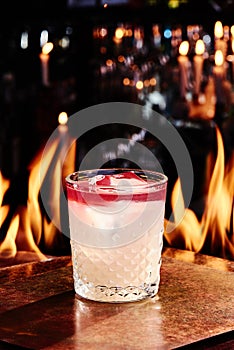 red and white layered cocktail with bitter in a Old-Fashioned glass on copper designer bar counter, the background of