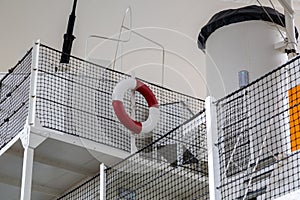 A red and white life ring on the upper deck of an old ship