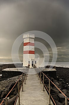 Red and white Lighthouse against dark sky