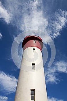 Red and White Lighthouse Extending Towards Blue Cloudy Sky