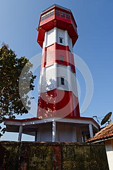 A Red and white lighthouse set against the sky