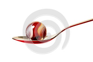 A Red and White Marble On A Spoon