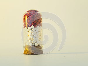 red and white masterbatch polymer granules in glass tube isolated on white background
