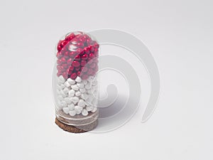 red and white masterbatch polymer granules in glass tube isolated on white background