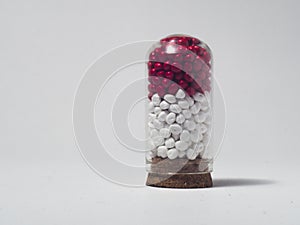 red and white masterbatch polymer granules in glass tube isolated on white background