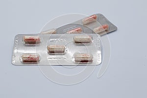 Red and white medicine capsules in foil and plastic packaging 3