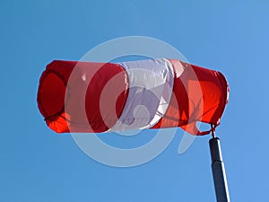 Red and white nylon textile tube windsock blown by the wind