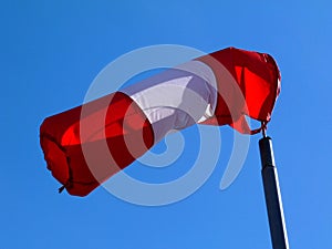 Red and white nylon textile tube windsock blown by the wind