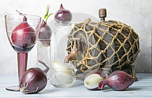 Red and white onions in glass goblets and a barrel of wine