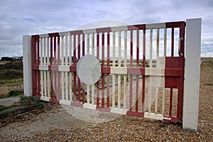 Red and white painted metal gate in Dungeness, Kent