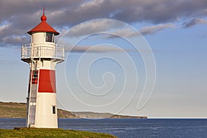 Red and white picturesque lighthouse. Faroe islands, Torshavn harbor