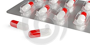 Red and white pill capsules in pill blister pack on white background with selective focus, medicine, pharmacy or drug concept