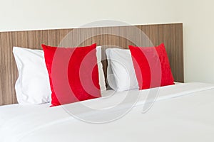 Red and white pillows on a bed