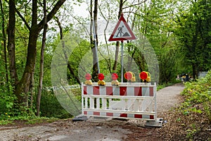 Red and white plastic portable barrier in front of a construction site. Road works sign