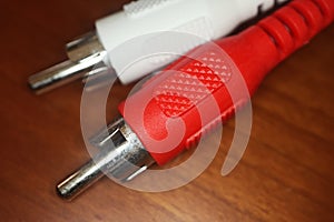 Red and white RCA plugs on wooden table. Macro photography