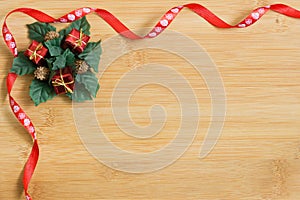 Red and white ribbon on light wood background with Christmas wreath decoration