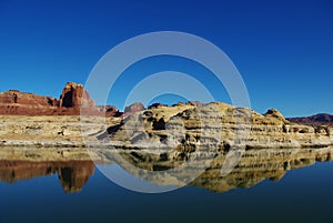 Red and white rock reflection in Colorado river near Hite, Utah