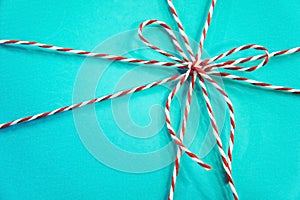 Red and white rope bow on a blue background. Turquoise gift box background