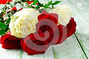 Red and white roses on wooden background