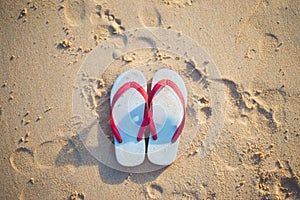 Red and white sandal on the beach