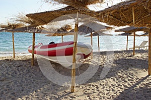 Red White SpeedBoat Under Beach Umbrella
