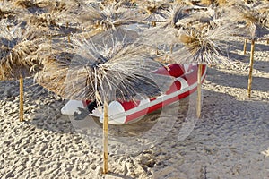 Red White SpeedBoat Under Beach Umbrella