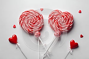 Red and white spiral lollypops with two red lollipops in the shape of a heart.