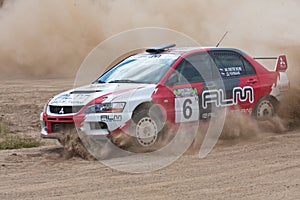 Red and white sport car Mitsubishi Lancer at rally