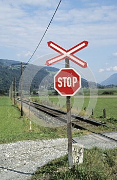 Red and white stop sign for people at railway crossing