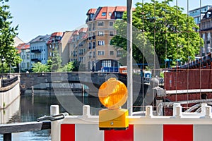 Red and white street barriers with flashlight to secure a construction site, roadworks, road under construction. Temporary fencing