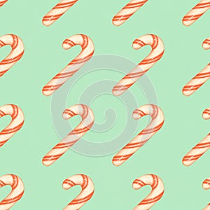 Red and white striped candy canes on a blue background. Christmas seamless pattern with candy canes