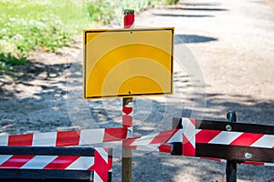 Red and white striped tape, danger and limited access warning. Empty yellow signboard and barricade tape, boundary line in the