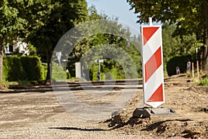 Red and white striped traffic control devices on the road being repaired
