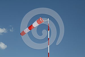 Red-white striped windsock on a pole photo