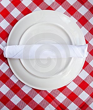 Red and white table cloth with plate