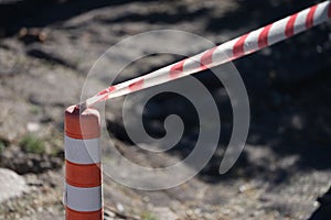 Red and white tape stretched in front of danger zone closeup