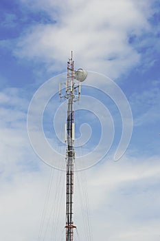 Red and White Telecommunication tower with blue sky and cloud