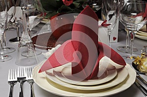 Red and white theme wedding breakfast dining table setting close up.