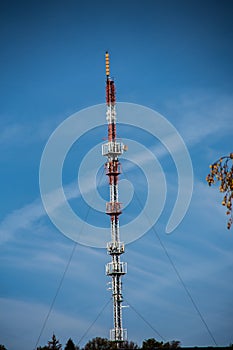 Red-white transmission mast braced with ropes photo