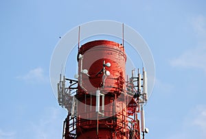 Red and white tube boiler with cables of telecommunications equipment, primarily for cellular transmission