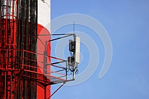 Red and white tube boiler with cables of telecommunications equipment, primarily for cellular transmission