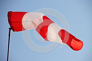 Red and white wind cone with blue sky as background